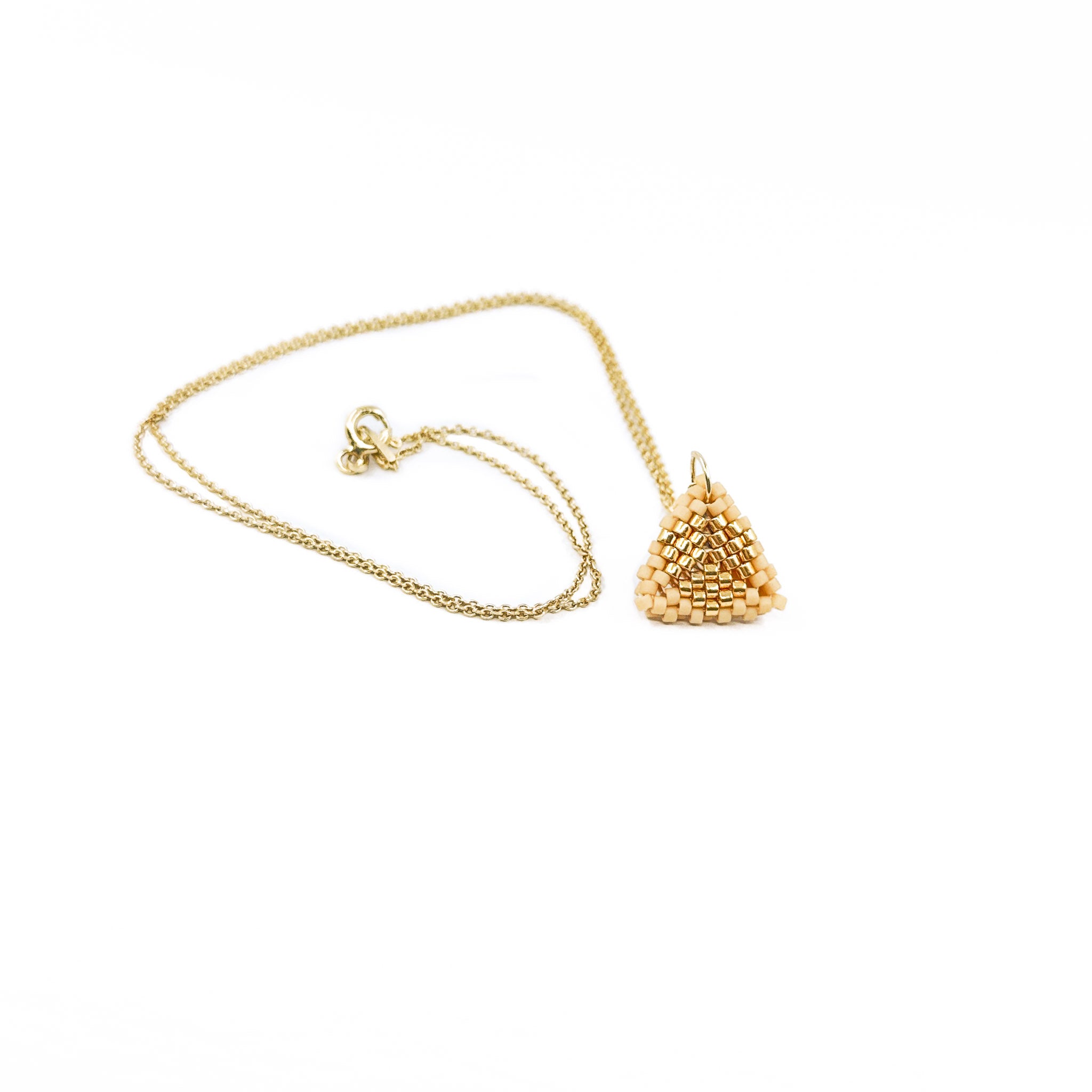 Beige beaded triangle pendant on a gold chain with metallic center detail, wheat color beads, front view.