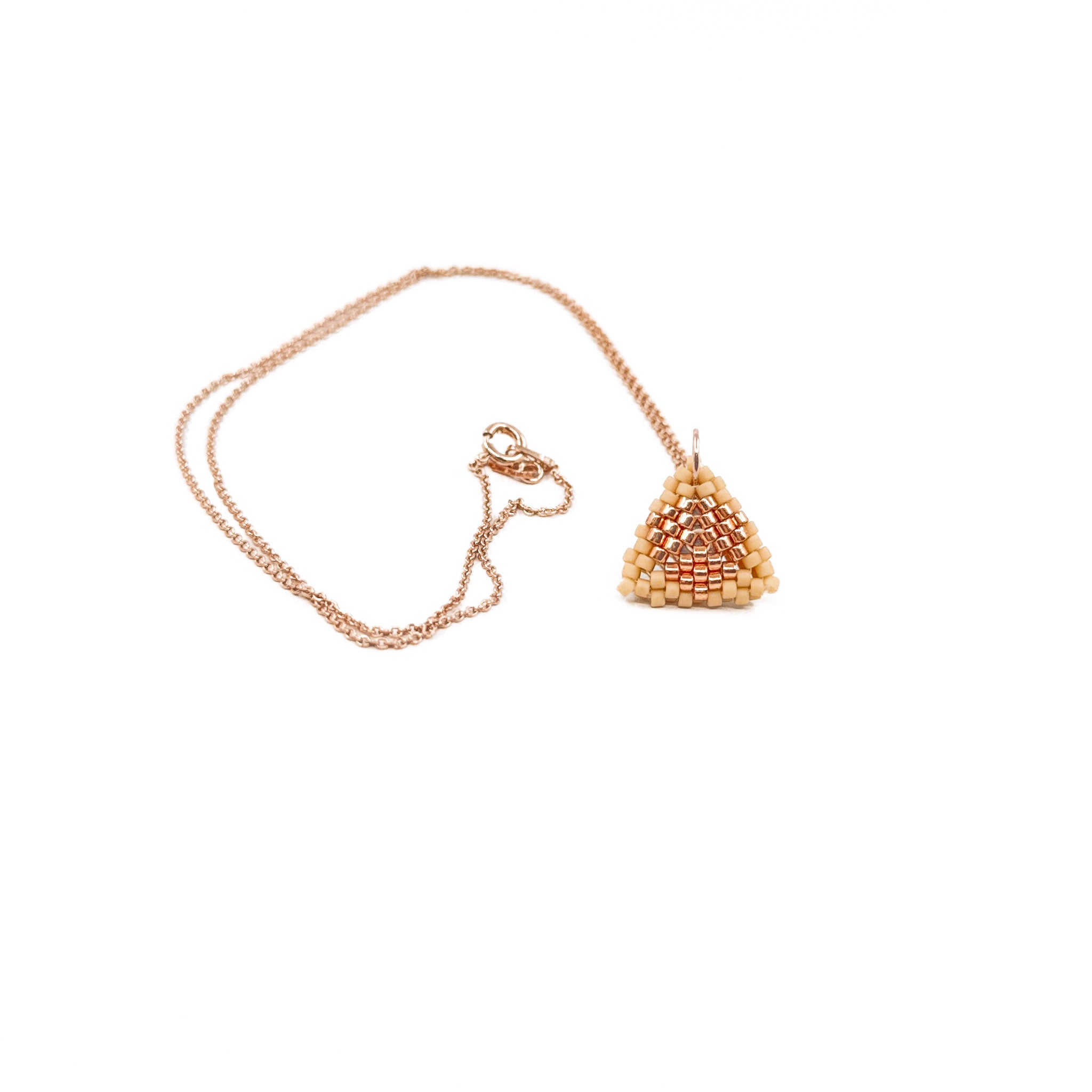 Beige beaded triangle pendant on a rose gold chain with metallic center detail, rosy beige beads, front view.
