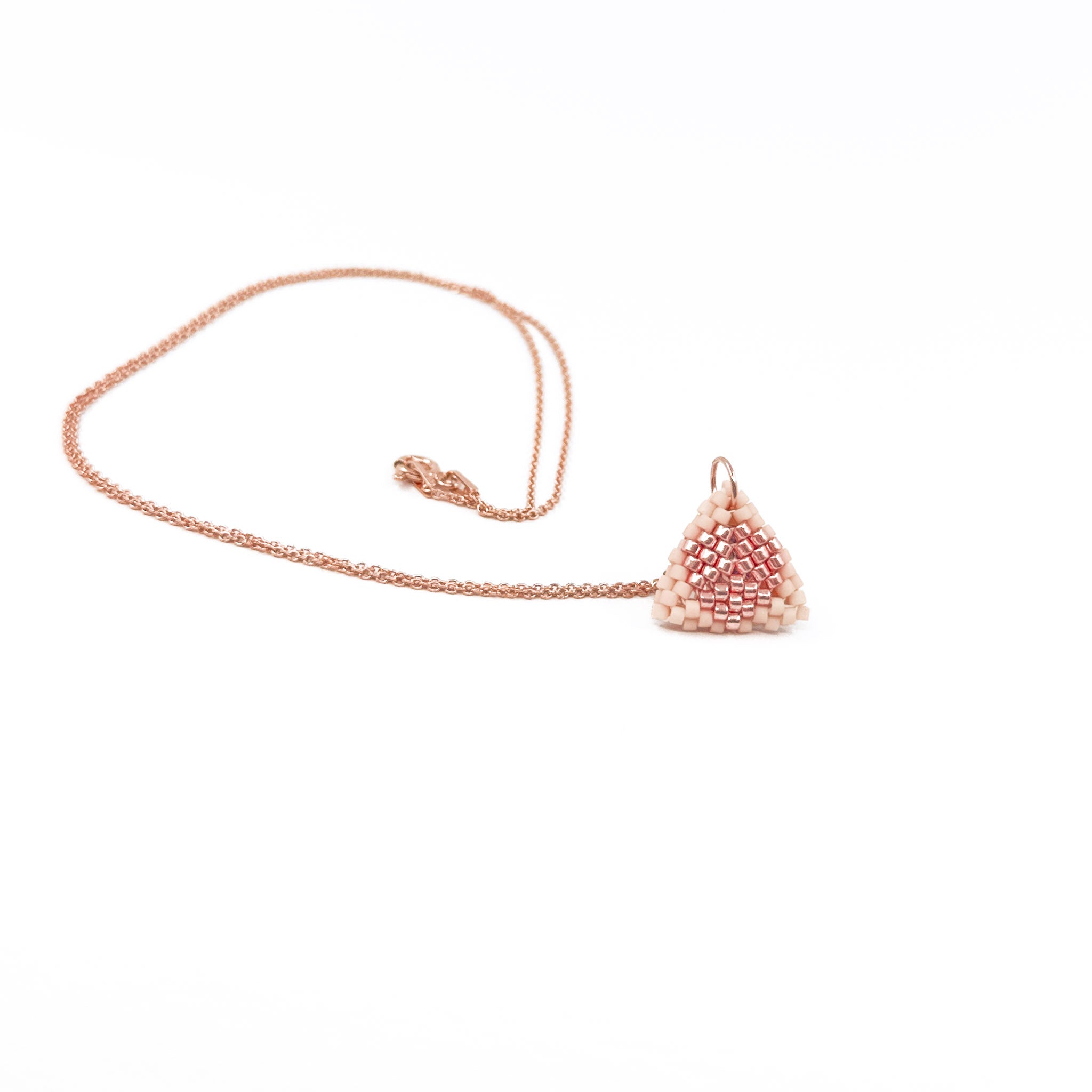 Pink beaded triangle pendant on a rose gold chain with metallic center detail, blush pink beads, front view.