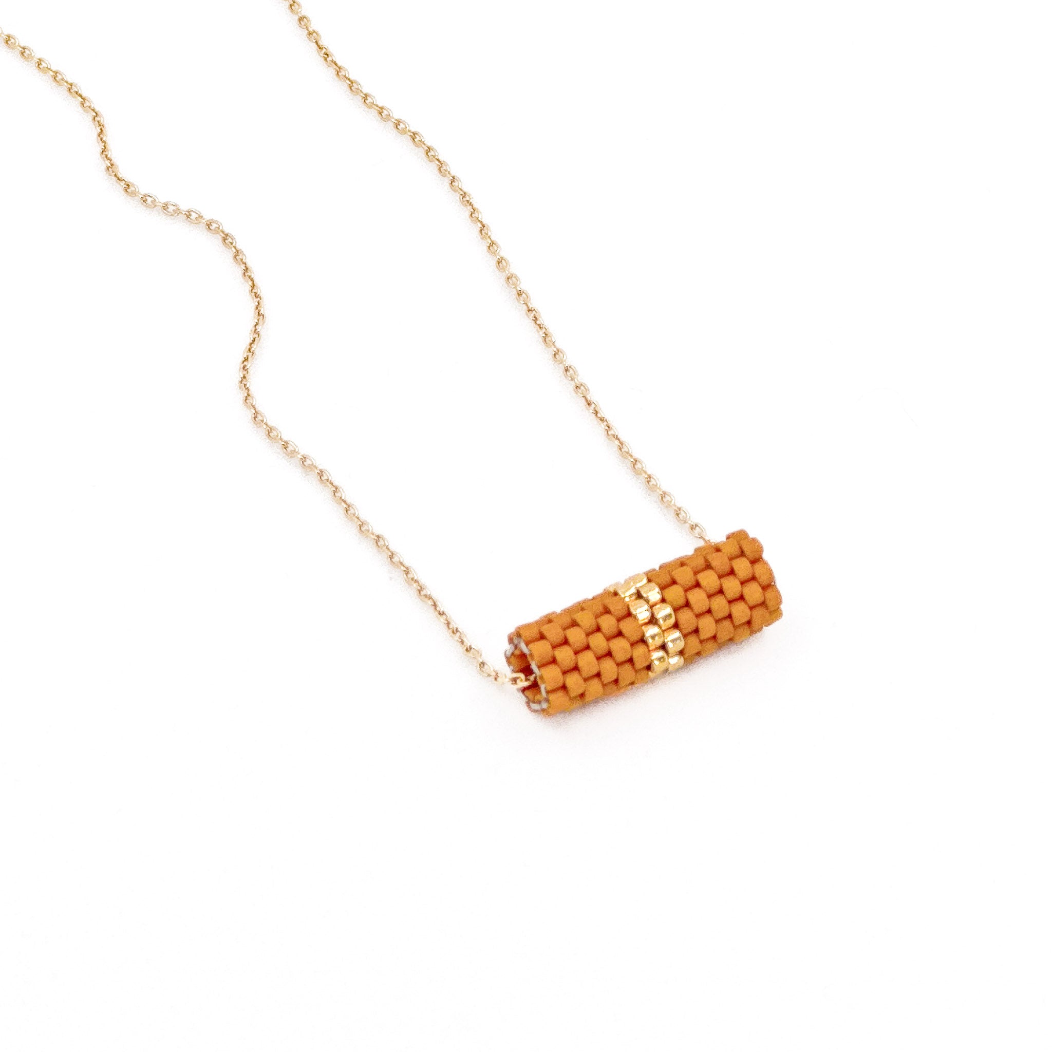 Orange beaded tube pendant necklace with gold chain and metallic center detail,  terracotta toned beads, side view.