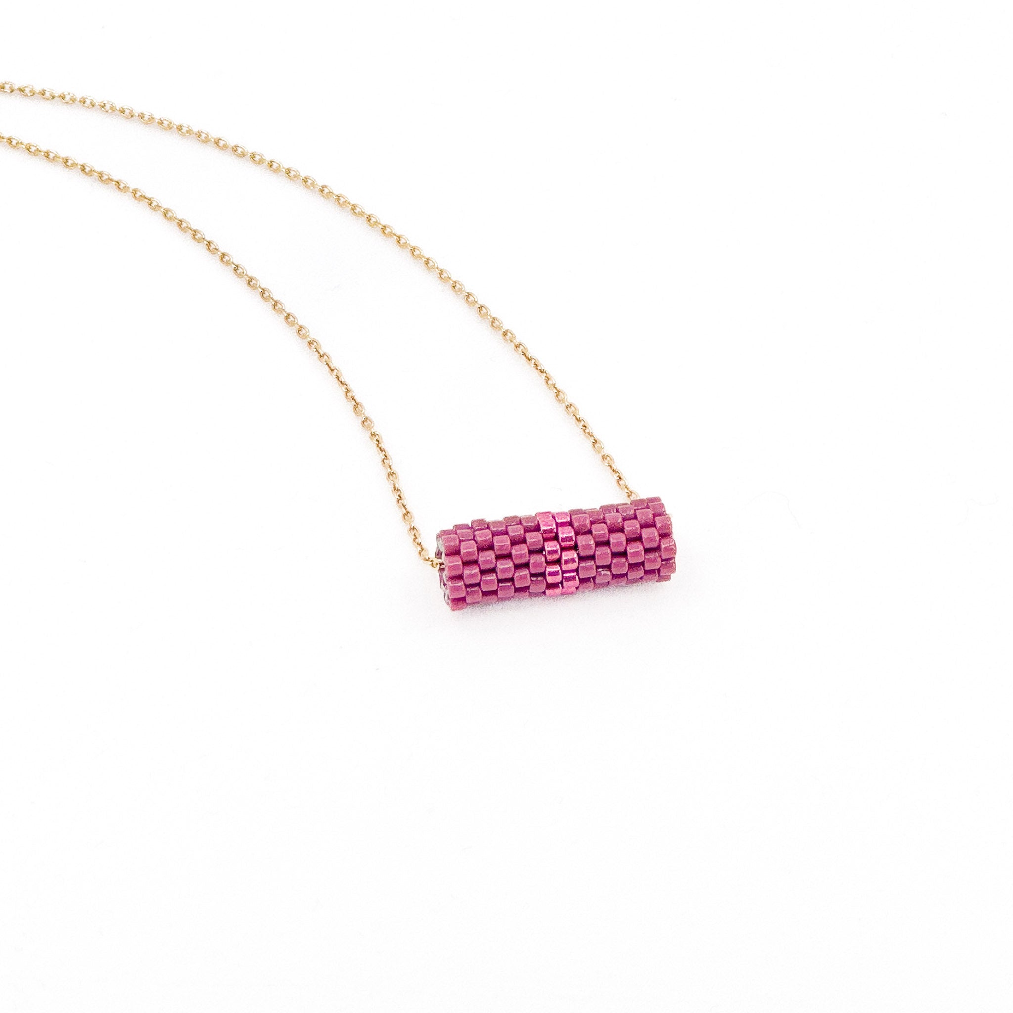 Pink beaded tube pendant necklace with gold chain and metallic center detail, berry pink beads, side view.